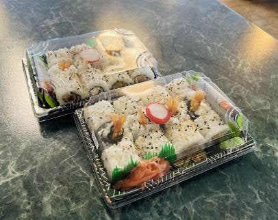 Zwei Sushi-Boxen zum Mitnehmen mit Inside-out-Rollen